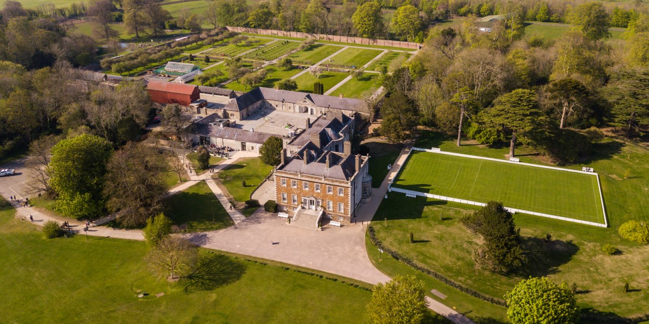 ariel view of red bricked house with farm in background